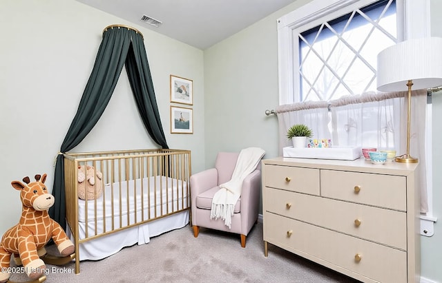 carpeted bedroom featuring visible vents and a nursery area