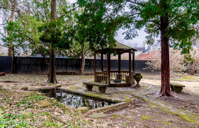 view of community with a gazebo and fence private yard