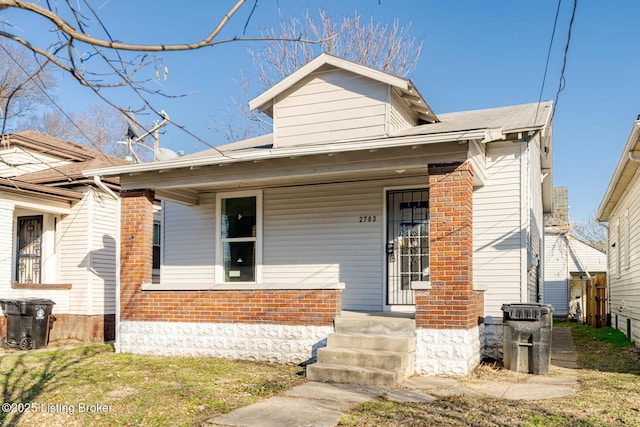 bungalow-style house featuring brick siding and a porch