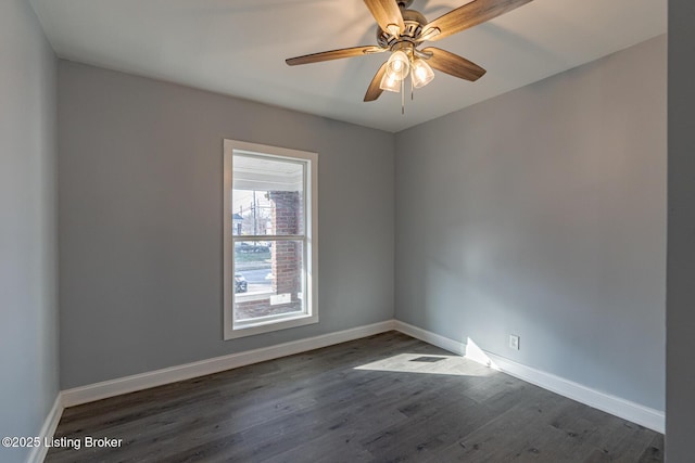 unfurnished room with dark wood-style floors, ceiling fan, and baseboards