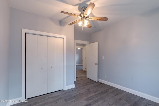 unfurnished bedroom with a closet, a ceiling fan, baseboards, and wood finished floors