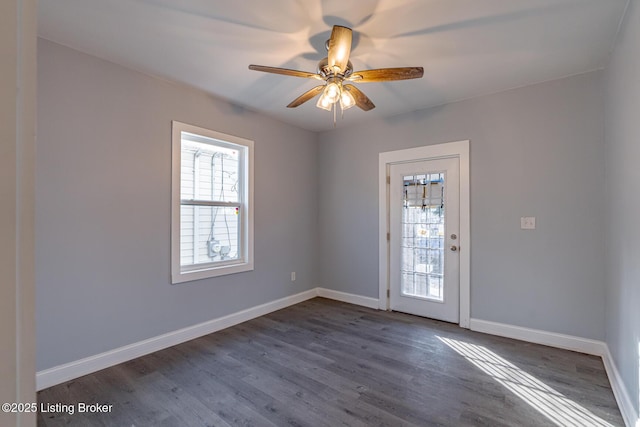 spare room with dark wood-style floors, baseboards, and ceiling fan