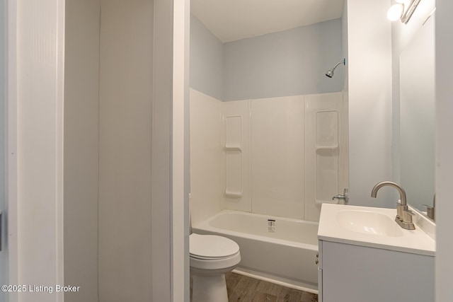 full bathroom featuring bathing tub / shower combination, toilet, wood finished floors, and vanity