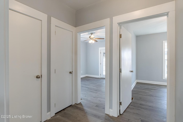 corridor featuring wood finished floors and baseboards