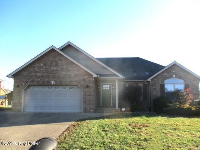 ranch-style home with a front lawn, brick siding, an attached garage, and driveway