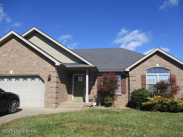 ranch-style house with brick siding, a front lawn, a shingled roof, and a garage