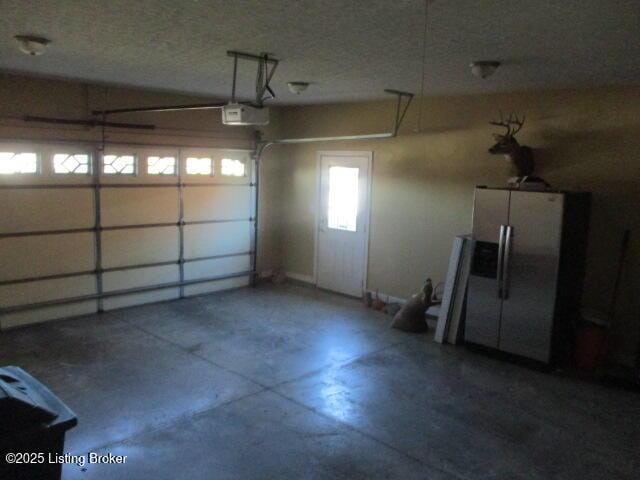 111 Pete Ln, Bardstown, KY 40004 - garage with a garage door opener and stainless steel refrigerator with ice dispenser