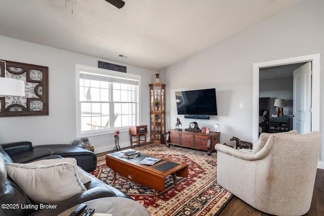 living room featuring ceiling fan, visible vents, wood finished floors, and vaulted ceiling