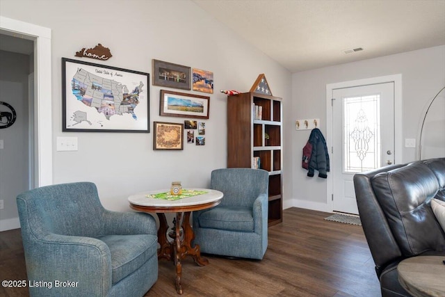 living area featuring visible vents, baseboards, and wood finished floors