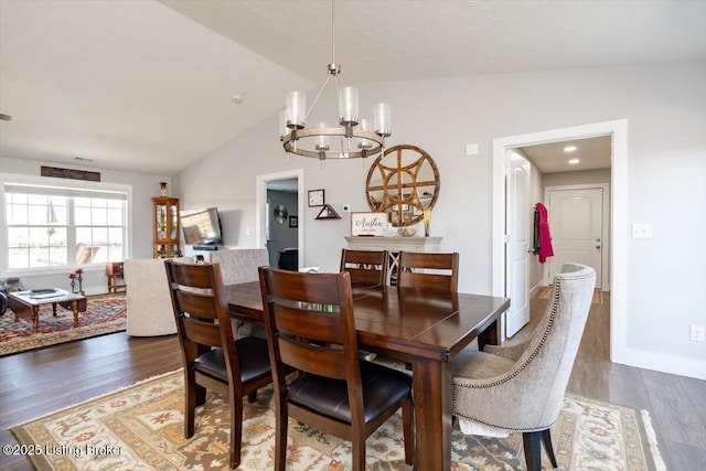 dining space with lofted ceiling, wood finished floors, baseboards, and a chandelier