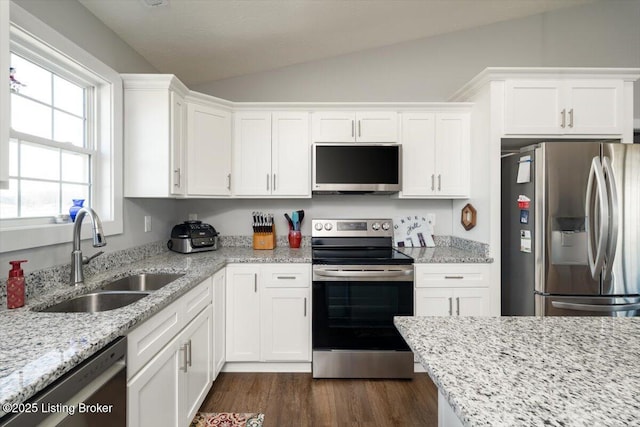 kitchen with dark wood-type flooring, lofted ceiling, stainless steel appliances, white cabinetry, and a sink