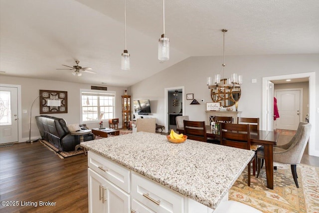 kitchen featuring open floor plan, dark wood finished floors, white cabinetry, lofted ceiling, and hanging light fixtures