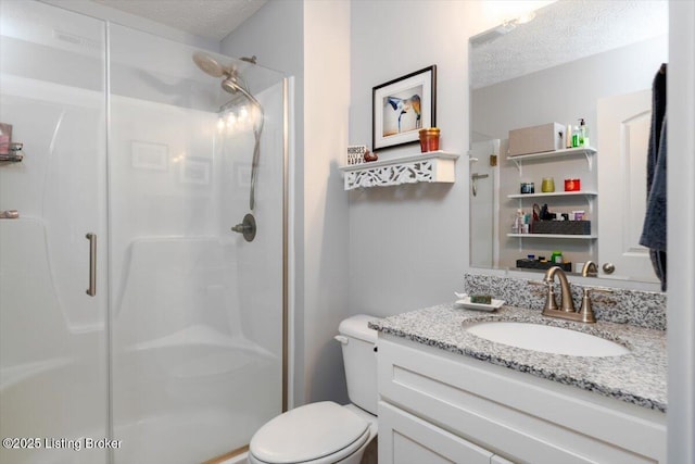 bathroom featuring vanity, a textured ceiling, a shower stall, and toilet