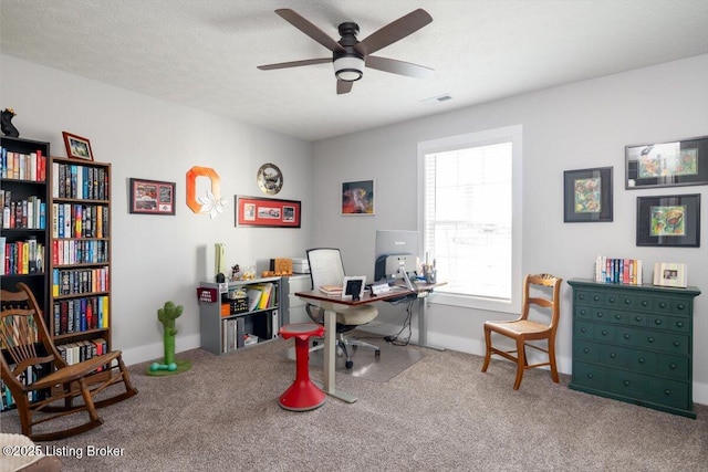 home office with visible vents, ceiling fan, a textured ceiling, and carpet