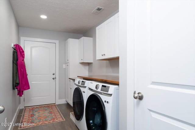 washroom with baseboards, cabinet space, a textured ceiling, independent washer and dryer, and dark wood-style flooring