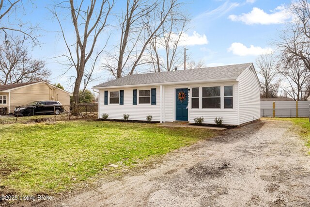 view of front of house featuring driveway, a shingled roof, a front lawn, and fence