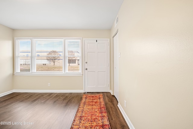 doorway to outside featuring visible vents, dark wood-style floors, and baseboards