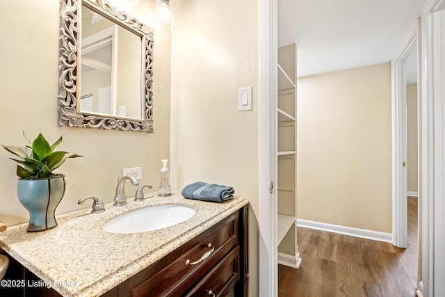 bathroom featuring vanity, wood finished floors, and baseboards