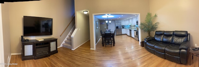 living area featuring stairway, wood finished floors, and baseboards