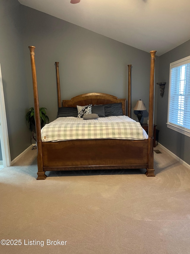 bedroom with carpet flooring, baseboards, and lofted ceiling