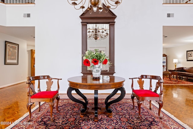 sitting room featuring visible vents, baseboards, an inviting chandelier, and a towering ceiling