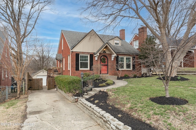 view of front of house featuring an outbuilding, driveway, fence, brick siding, and a chimney