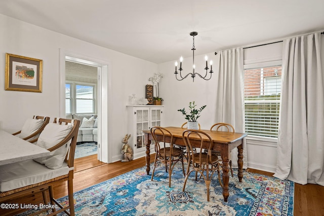 dining room featuring baseboards, an inviting chandelier, and wood finished floors