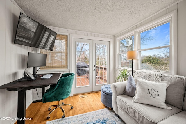 office area featuring french doors, plenty of natural light, a textured ceiling, and wood finished floors