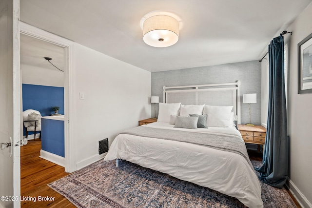 bedroom featuring baseboards and wood finished floors