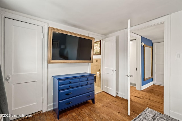 bedroom with baseboards and wood finished floors