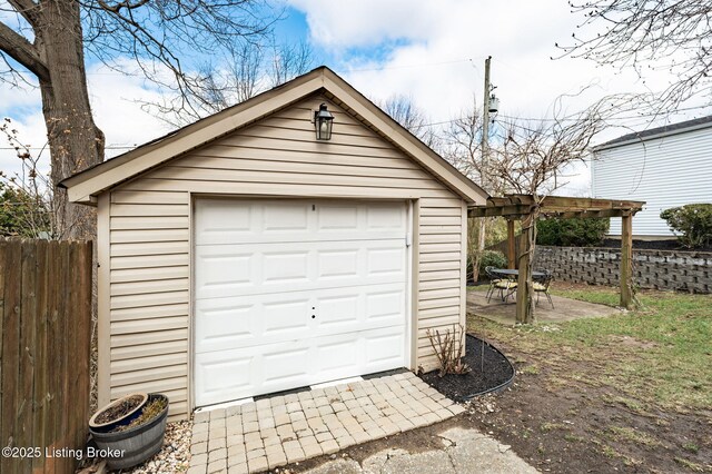 detached garage featuring fence