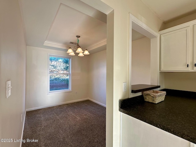 unfurnished dining area with visible vents, baseboards, an inviting chandelier, a raised ceiling, and carpet flooring