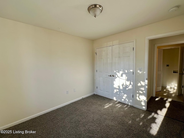 unfurnished bedroom with carpet flooring, baseboards, and a closet