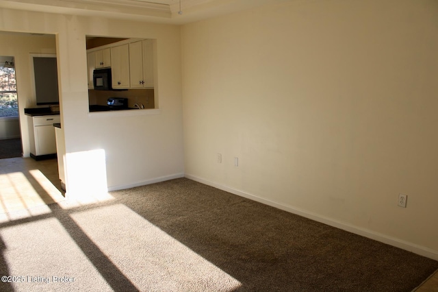 empty room featuring carpet and baseboards