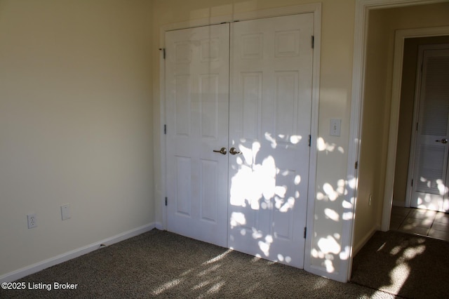 unfurnished bedroom featuring a closet, carpet flooring, and baseboards