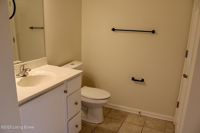 half bath with tile patterned flooring, toilet, vanity, and baseboards