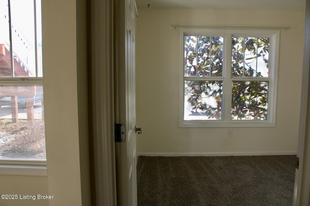 empty room featuring carpet and baseboards