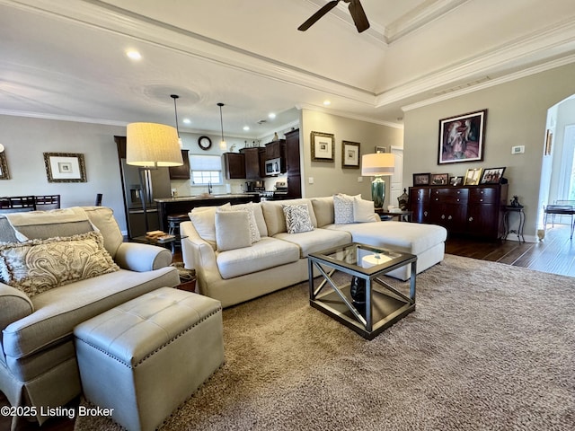 living area with visible vents, arched walkways, ornamental molding, and dark wood-style flooring