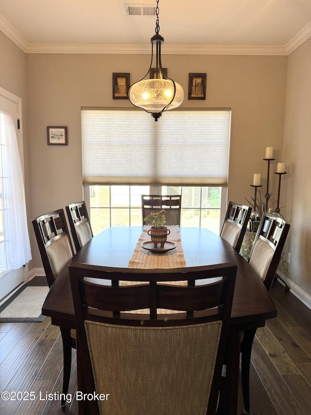 dining area featuring baseboards, hardwood / wood-style floors, and crown molding