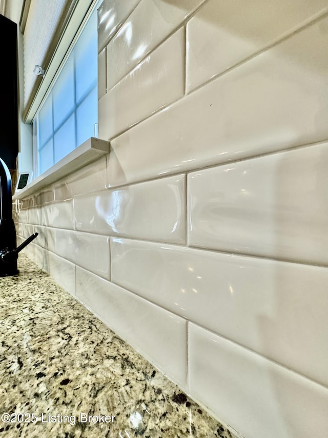 room details with light stone countertops and backsplash