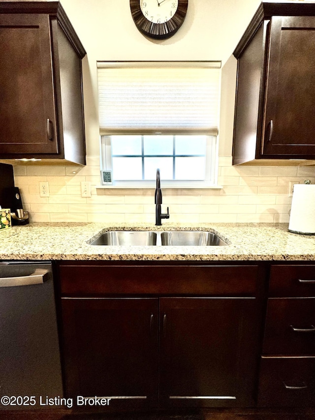 kitchen featuring tasteful backsplash, dark brown cabinets, stainless steel dishwasher, and a sink