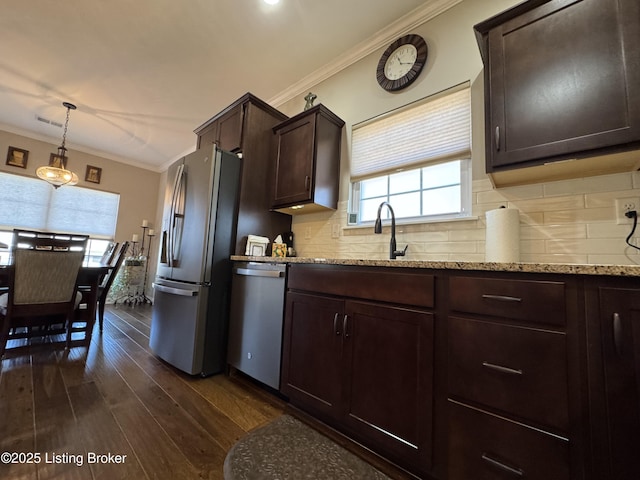 kitchen with backsplash, crown molding, appliances with stainless steel finishes, dark wood-style floors, and a sink