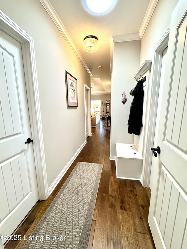 hallway with hardwood / wood-style floors, baseboards, and ornamental molding