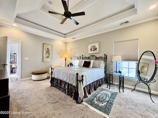 bedroom with visible vents, baseboards, a tray ceiling, ornamental molding, and carpet floors