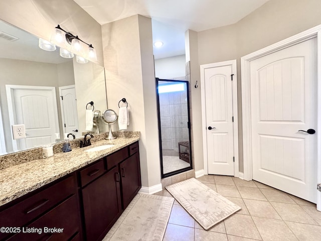 bathroom with vanity, baseboards, visible vents, a stall shower, and tile patterned flooring