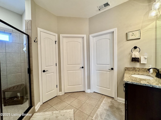 full bathroom with tile patterned floors, visible vents, a shower stall, baseboards, and vanity