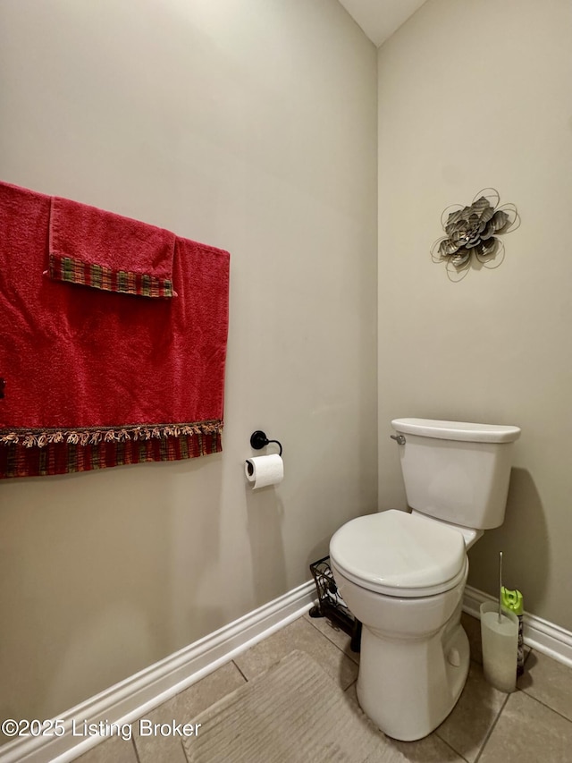 bathroom featuring baseboards, toilet, and tile patterned flooring