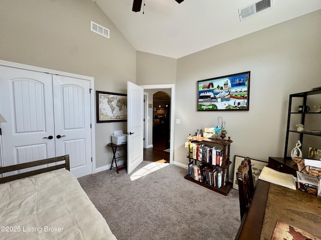 carpeted bedroom featuring a ceiling fan, arched walkways, visible vents, and a closet