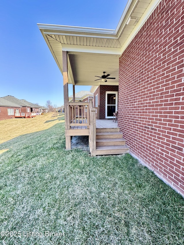 view of yard featuring a deck and ceiling fan