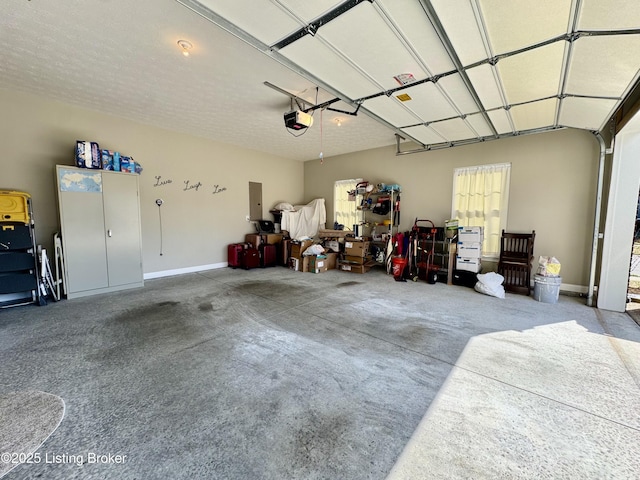 garage with electric panel, a garage door opener, and baseboards